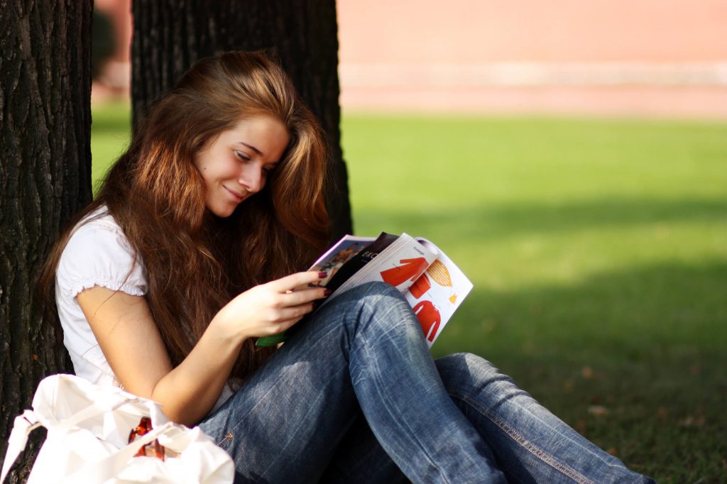 Mulher lendo revista sobre para melhorar a comunicação na Publicação Digital