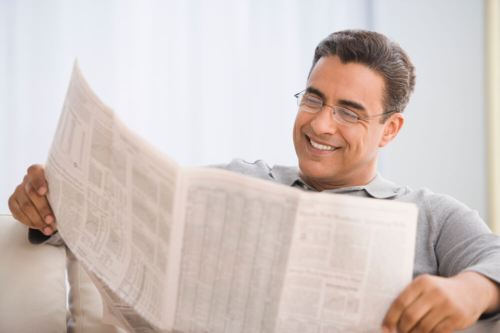 Pessoa lendo jornal impresso