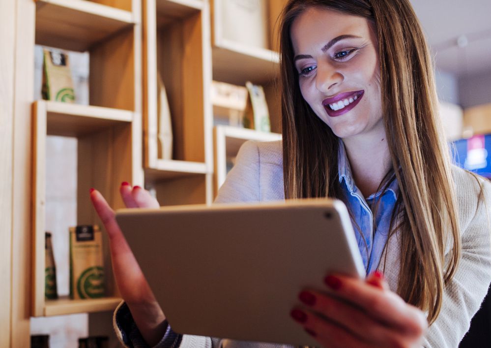 Mulher olhando jornal impresso no tablet